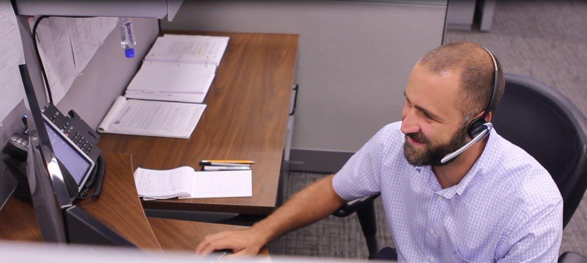 support man with headset at computer